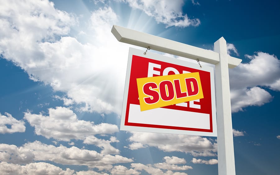 Sold For Sale Real Estate Sign over Clouds and Blue Sky with Sun Rays ...